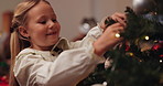 Christmas, child and happy at tree with ornament, decoration and festive season celebration. Xmas tradition, girl kid and trimmings in home for aesthetic, creativity or excited for holiday activities