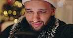 Christmas, smile and man with smartphone, reading and happy with holiday message, online and festive. Season, hat and person in living room, watch and movies of celebration, subscription and joy