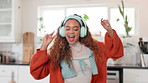 Happy girl, listening and dancing with headphones for music or cooking recipe in kitchen at home. Young, female person or freelancer with headset for fun meal preparation or hospitality at house