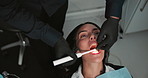 Woman, dentist and hands with light in mouth for check, inspection and hygiene for healthcare at clinic. Doctor, person and equipment for oral wellness, cleaning and above with teeth at hospital