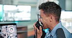 Security guard, man and discussion with radio in office for surveillance, feedback or crime watch. Cctv, report and worker with communication in control room for building safety, protection or update