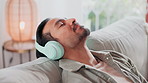 Home, music and man with headphones on sofa for entertainment, streaming and listening to audio. Person, relax and technology with eyes closed in living room for sound, peace and song on playlist