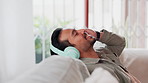 Home, happy and man with headphones on sofa for entertainment, streaming and listening to music. Relax, technology and person with eyes closed in living room for sound, audio and song on playlist