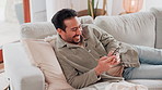 Home, smile and man with smartphone, comfort and internet for social media, connection and typing. Happy person, apartment and guy on couch, cellphone and digital app for email, chatting and laughing