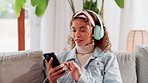 Woman, phone and headphones on sofa in home for listening to music, streaming service or social media scroll. Happy person, smartphone and relax on couch for radio app, audio subscription and podcast