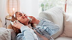 Relax, peace and woman with headphones on sofa for streaming, entertainment and listening to song. Home, technology and person with eyes closed in living room for audio, sound and music on playlist