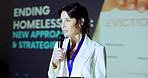 Woman, speaker and discussion at conference, stage and information with solution for homeless crisis. Person, speech and mic for overpopulation, growth and talking for problem solving at convention