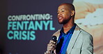 Explaining, stage and man with mic, event and serious for fentanyl crisis, healthcare and speaker. Workshop, presentation and public speaking in seminar, communication and black person with ideas