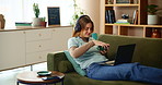 Woman, relax and headphones with laptop on sofa for listening music, education podcast and coffee break. Smile, girl and digital with headset for streaming, herbal tea and audio sound on web at house