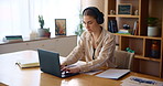 Home office, headphones and woman typing on laptop for remote work, email or research on internet. Computer, freelancer and girl listening to music, podcast or virtual assistant schedule appointment