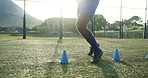 Feet, athlete and cone with soccer outdoor for fitness practice, running guide and exercise performance. Person, equipment and warm up challenge with football, sports skill and game training on field