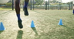 Feet, person and jump with cone for soccer of fitness practice, warm up guide and exercise performance. Athlete, beacon and routine with football challenge, sports progress and game training on field