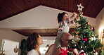 Parents, child and decorate on Christmas tree for festive, holiday and celebration as happy family in home. People, together and bonding with activity, lights and living room for vacation in December