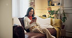 Relax, phone and woman with coffee on sofa for online chatting, social media and contact on weekend. Happy, home and person on smartphone for internet, website and communication in living room