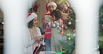 Family, parents and child decorate Christmas tree to celebrate festive holiday by window. Mother, father and girl with xmas ornament to help prepare for party, learning and happiness in home lounge