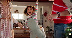 Parents, girl and happy with dancing on Christmas at home for fun, break and celebration. People, family and smile with kid jumping in living room on festive season for unity, love and support