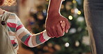 Christmas, December and parent holding hands with child closeup in living room of home for celebration. Family, festive and holidays with people together in apartment for love, support or tradition