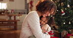 Christmas, hug or smile with mother and daughter in living room of home together for celebration. December, family and tree with single parent woman embracing girl child in apartment for bonding