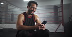 Boxing, smile and man in gym with phone checking meme, online chat or funny social media video. Laughing, streaming and happy boxer in ring with smartphone reading fitness app, text or post at club