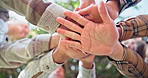 Hands, huddle and solidarity with group of people outdoor from below for celebration or motivation. Palm, team building and trust with circle of friends in nature for bonding or success together