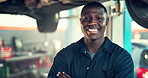 Mechanic, face and arms crossed with black man and car in auto repair shop for diagnostic, transport or calibration. Engineering, maintenance or motor technician with portrait of person in garage 