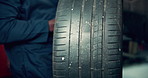 Black man, remove and change tire for car repair, alignment and vehicle maintenance with service in garage. Mechanic, fix and wheel for road safety, performance and inspection in automobile workshop