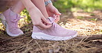 Woman, hands and tying laces with shoes in forest for hiking, running or exercise in nature. Closeup, female person or tie with bow in fitness, woods or getting ready for journey, adventure or walk