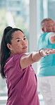 Mature woman, exercise and yoga class at gym for healthy body, balance and fitness in retirement. Female person, yogi and warrior pose at health club for wellness, support and workout in morning