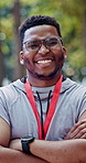 Medal, confident and face of black man at race in nature with pride for fitness goal or achievement. Happy, crossed arms and portrait of male athlete with gold award for marathon with cardio exercise