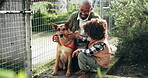 Smile, black family and play with animal at shelter of adoption service, homeless dogs and rescue centre. Father, child and bonding by fence for safety, foster care and pet welfare with charity ngo
