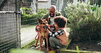 Happy, black family and play with animal at shelter of adoption service, homeless dogs and rescue centre. Father, child and bonding by fence for safety, foster care and pet welfare with charity ngo
