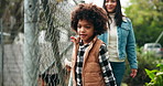 Boy, dog and adoption at fence at shelter with mom, search and outdoor with check for homeless pet. Child, mother and smile for charity, kindness and family at abandoned animal center in Colombia