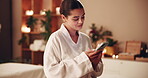 Woman, customer and relax at spa with smartphone on internet, social media and online dating. Female person, client and browsing website on massage at resort for health benefits, break and luxury
