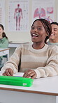 Education, laughing and student black woman at desk in classroom for lecture, lesson or study. Funny, happy and smile of learner at college, school or university for growth, learning and development