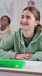 Education, laughing and student woman at desk in classroom for lecture, lesson or study. Funny, happy and smile of learner with braces at college, school or university for learning and development