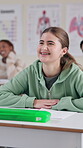 Education, funny and student woman at desk in classroom for lecture, lesson or study. Happy, laughing and smile of learner with braces at college, school or university for learning and development