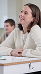 Education, funny and student woman at desk in classroom for lecture, lesson or study. Humor, laughing and smile of happy learner at college, school or university for growth, learning and development