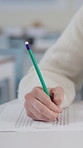 Hands, writing and student with test in classroom at school for scholarship admission question paper. Education, learning and closeup of person studying with practice exam, assignment or project.