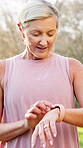 Senior woman, exercise and smart watch in nature for workout, information and training progress. Digital, check and person with technology in forest for monitoring heart rate, tracker and fitness app