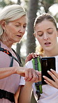 Mother, daughter and hiking in forest with phone for map, 
internet navigation and talk for travel direction. Mature woman, girl and smartphone in woods for path research, location or trekking break