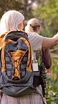 Women, back and hiking with backpack in nature for travel, adventure or outdoor journey together. Female person, friends or group trekking with bag for fitness, workout or exercise in forest or woods