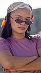 African girl, fashion and confident outdoor for gen z streetwear, outfit and serious with shades. Female person, trendy and face in city for cool street culture, clothes or style with crossed arms