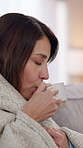 Sick, woman and tea for cold, flu and illness with blanket for wellness and comfort on living room sofa. Girl, coffee or hot drink for health, virus or allergy with rest and mug to relax in lounge