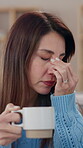 Tired,  woman and headache with coffee at house from burnout, brain fog and stress of bankruptcy problem. Female person, migraine and fatigue for strain massage, herbal tea and vertigo of debt crisis