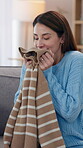 Woman, home and smell jersey for laundry in living room on couch for house keeping and hygiene. Female person, sofa and happy or smile for fabric scent, clothes and fresh line for housekeeping