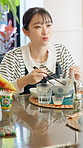 Asian woman, chat or eating in restaurant with chopsticks, bowl and lunch for nutrition. Listening, girl and meal for health, Chinese food and diet with noodles at cafeteria, diner or brunch in China