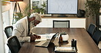 Senior, businessman and writing with documents in boardroom for corporate revenue or budget at office. Mature, male person or employee with paperwork for business analytics or report at workplace