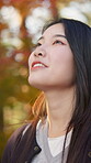 Face, peace and thinking with Asian woman outdoor in nature or park for calm or quiet closeup. Adventure, breeze and remote with happy person at forest in Japan for autumn future, planning or vision