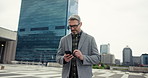 Phone, walking and business man in city for real estate sale, property development or reading email. Mobile, travel and mature manager in urban street to scroll chat app, text or notification online