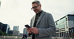 CEO, phone and businessman typing in city for real estate sale, property development or reading email. Mobile, smile or mature manager in urban street for chat app, travel or notification on internet